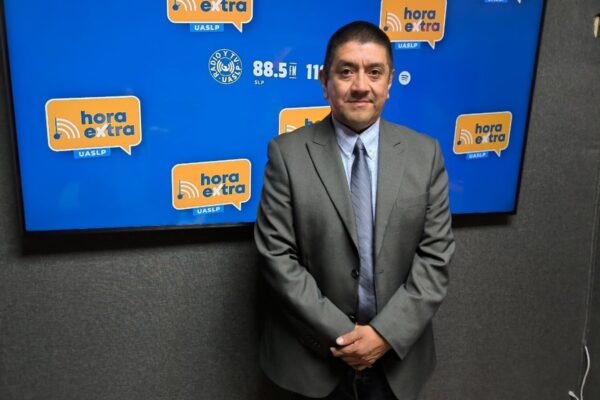 Orlando Guarneros García, investigador de la UASLP, frente a la imagen institucional de Radio y TV UASLP